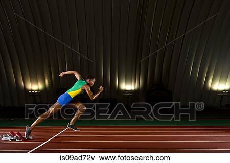 Young woman sprinting from starting blocks in stadium View Large Photo Image Stock Photo - Young woman sprinting from starting blocks in stadium. Fotosearch