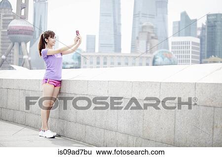 Young woman taking photograph in Shanghai, China View Large Photo Image Stock Photograph - Young woman taking photograph in Shanghai, China. Fotosearch