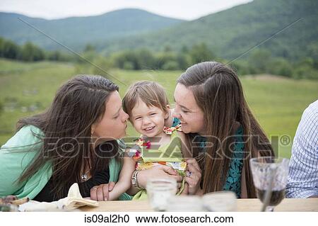 Baby girl sitting between two young women View Large Photo Image Stock Image - Baby girl sitting between two young women. Fotosearch