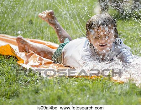 Boy playing with garden sprinkler View Large Photo Image Stock Photography - Boy playing with garden sprinkler. Fotosearch