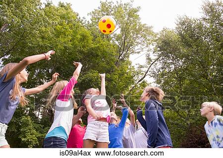 Stock Photo - Children playing ball game in garden. Fotosearch