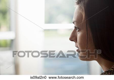 Close up portrait of young woman gazing out of window View Large Photo Image Stock Image - Close up portrait of young woman gazing out of window. Fotosearch