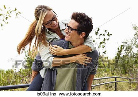 Couple playing piggyback ride in park View Large Photo Image Stock Photo - Couple playing piggyback ride in park. Fotosearch