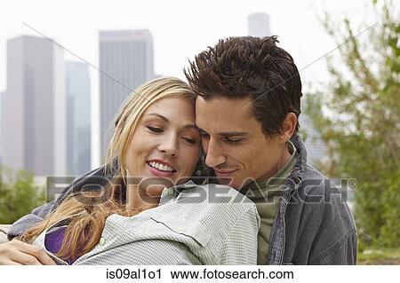 Couple relaxing in park by city View Large Photo Image Stock Image - Couple relaxing in park by city. Fotosearch