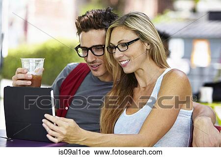 Couple using digital tablet at cafe View Large Photo Image Stock Image - Couple using digital tablet at cafe. Fotosearch