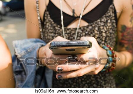 Cropped shot of young woman texting on smartphone View Large Photo Image Picture - Cropped shot of young woman texting on smartphone. Fotosearch