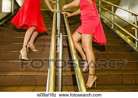 Cropped view of two young women wearing red dresses on subway stairs View Large Photo Image Stock Photo - Cropped view of two young women wearing red dresses on subway stairs. Fotosearch