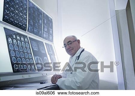 Stock Photograph - Doctor analysing scan results. Fotosearch