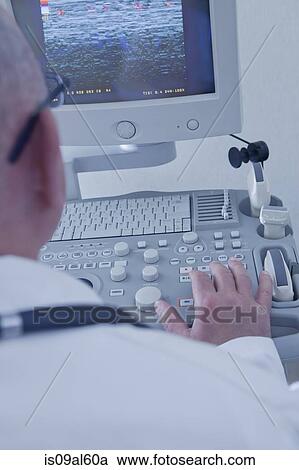 Stock Image - Doctor operating ultrasound scanner. Fotosearch