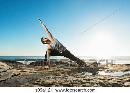 Stock Image - Extended Side Angle Pose - Utthita Parsvakonasana, Windansea beach, La Jolla, California. Fotosearch