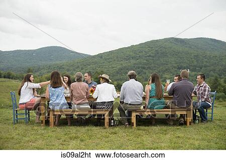 Family and friends making a toast at outdoor meal View Large Photo Image Stock Photograph - Family and friends making a toast at outdoor meal. Fotosearch