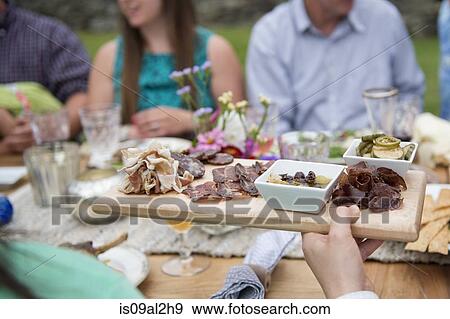 Stock Photo - Family having meal together, outdoors. Fotosearch