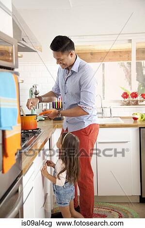 Stock Image - Father and daughter cooking in kitchen. Fotosearch