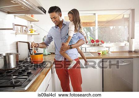 Stock Image - Father and daughter cooking in kitchen. Fotosearch