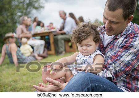 Father playing with daughter at family gathering, outdoors View Large Photo Image Stock Image - Father playing with daughter at family gathering, outdoors. Fotosearch