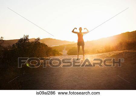 Female jogger flexing arms in sunlight, Poway, CA, USA View Large Photo Image Stock Photograph - Female jogger flexing arms in sunlight, Poway, CA, USA. Fotosearch