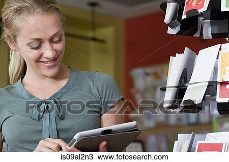 Female sales assistant using digital tablet in stationery shop View Large Photo Image Stock Image - Female sales assistant using digital tablet in stationery shop. Fotosearch
