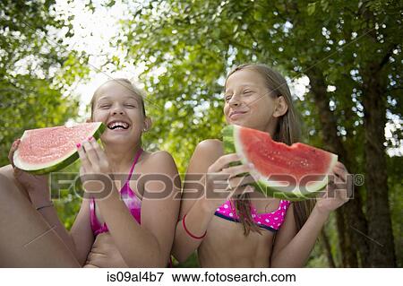 Friends eating watermelon in garden View Large Photo Image Stock Photo - Friends eating watermelon in garden. Fotosearch