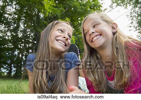 Friends lying on grass View Large Photo Image Stock Photography - Friends lying on grass. Fotosearch