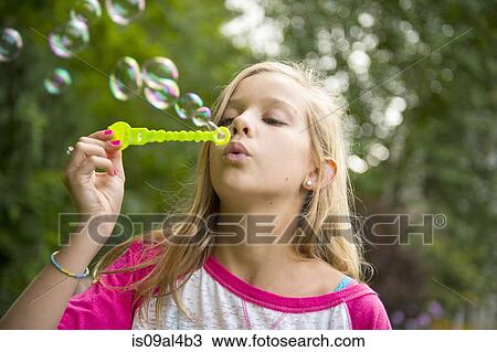 Girl blowing bubbles in garden View Large Photo Image Stock Image - Girl blowing bubbles in garden. Fotosearch