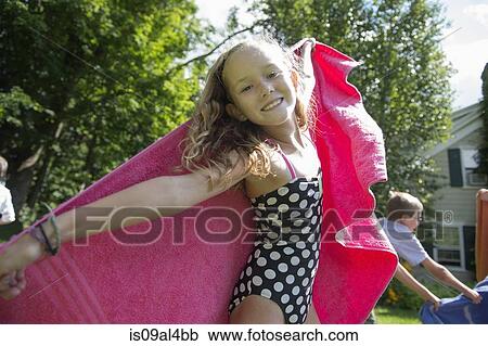 Stock Image - Girl in swimming costume holding towel. Fotosearch