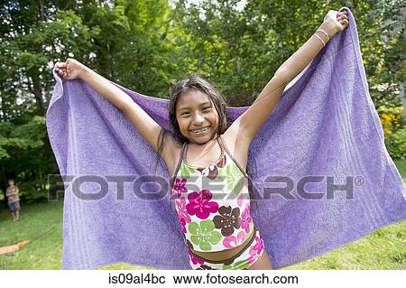 Stock Image - Girl in swimming costume holding towel. Fotosearch