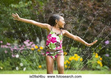 Girl in swimming costume playing with garden sprinkler View Large Photo Image Stock Photograph - Girl in swimming costume playing with garden sprinkler. Fotosearch