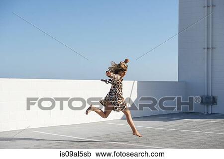 Girl jumping barefoot on building rooftop View Large Photo Image Stock Image - Girl jumping barefoot on building rooftop. Fotosearch