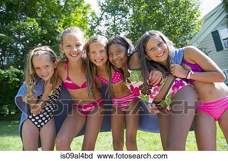 Stock Image - Girls in swimming costume wrapped in towel. Fotosearch