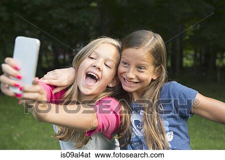 Girls taking selfie in garden View Large Photo Image Stock Photograph - Girls taking selfie in garden. Fotosearch