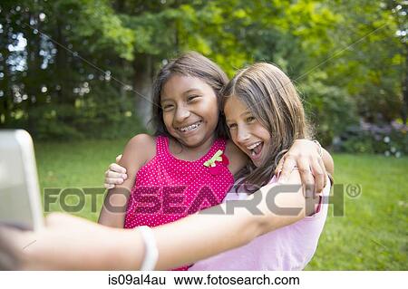 Girls taking selfie in garden View Large Photo Image Stock Photograph - Girls taking selfie in garden. Fotosearch