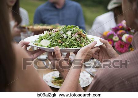 Group of adults enjoying meal, outdoors View Large Photo Image Stock Image - Group of adults enjoying meal, outdoors. Fotosearch