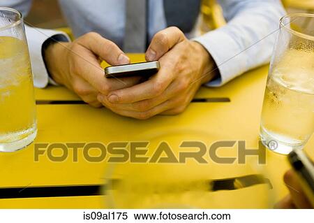 Hands of young man texting on smartphone at sidewalk cafe View Large Photo Image Stock Photography - Hands of young man texting on smartphone at sidewalk cafe. Fotosearch