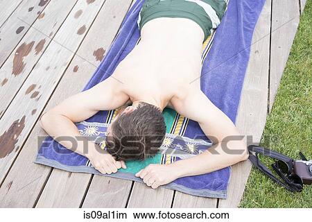 Picture - Man lying face down on wooden floor. Fotosearch