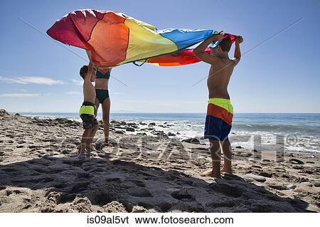 Mature woman and two sons holding up multi colored textile on beach, County Park, Los Angeles, California, USA View Large Photo Image Stock Photograph - Mature woman and two sons holding up multi colored textile on beach, County Park, Los Angeles, California, USA. Fotosearch