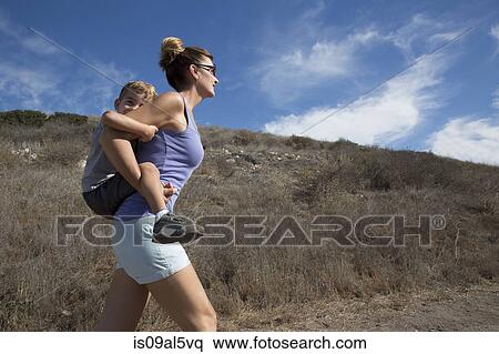 Stock Photography - Mature woman giving son a piggy back up hill, County Park, Los Angeles, California, USA. Fotosearch