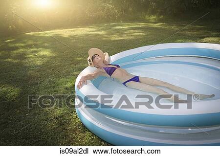 Mature woman relaxing in paddling pool View Large Photo Image Stock Image - Mature woman relaxing in paddling pool. Fotosearch