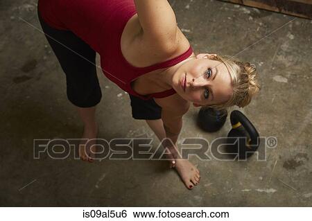 Mid adult female crossfitter lifting kettlebells in gym View Large Photo Image Stock Photograph - Mid adult female crossfitter lifting kettlebells in gym. Fotosearch