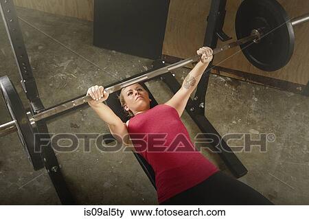 Mid adult female weightlifter lifting barbell in gym View Large Photo Image Stock Photo - Mid adult female weightlifter lifting barbell in gym. Fotosearch