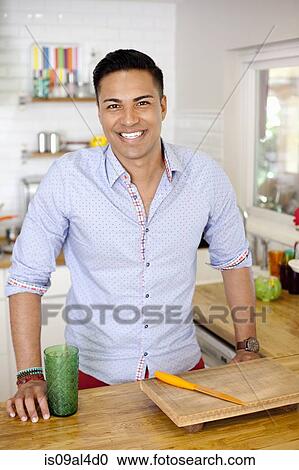 Stock Image - Mid adult man in kitchen, portrait. Fotosearch