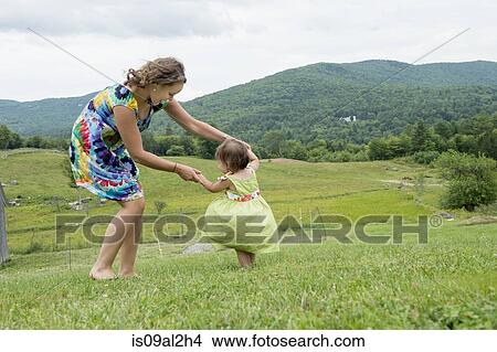 Mother and daughter dancing together in field View Large Photo Image Picture - Mother and daughter dancing together in field. Fotosearch