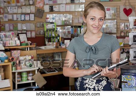 Portrait of female sales assistant using digital tablet in stationery shop View Large Photo Image Picture - Portrait of female sales assistant using digital tablet in stationery shop. Fotosearch