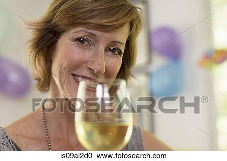 Portrait of mature woman holding glass of wine View Large Photo Image Stock Image - Portrait of mature woman holding glass of wine. Fotosearch