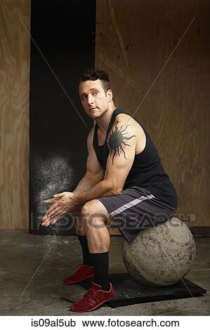 Portrait of mid adult male crossfitter sitting on atlas ball in gym View Large Photo Image Stock Image - Portrait of mid adult male crossfitter sitting on atlas ball in gym. Fotosearch
