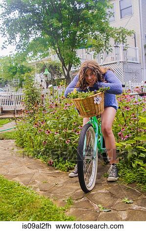 Stock Image - Portrait of teenager girl on bicycle, outdoors. Fotosearch
