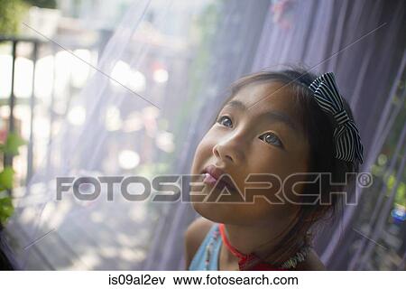 Stock Photo - Portrait of young asian girl, head and shoulders, close-up. Fotosearch