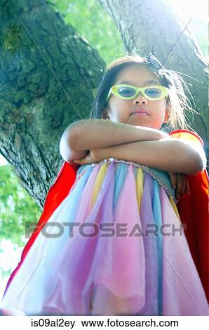 Stock Photo - Portrait of young girl wearing fancy dress costume, low angle view. Fotosearch