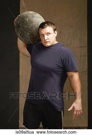 Portrait of young male weightlifter with atlas ball on shoulder in gym View Large Photo Image Stock Image - Portrait of young male weightlifter with atlas ball on shoulder in gym. Fotosearch