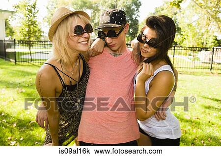 Portrait of young man and two female friends in upside down sunglasses View Large Photo Image Stock Image - Portrait of young man and two female friends in upside down sunglasses. Fotosearch