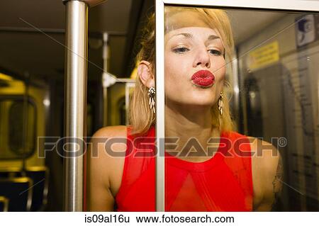 Portrait of young woman on subway train kissing glass partition View Large Photo Image Stock Photograph - Portrait of young woman on subway train kissing glass partition. Fotosearch